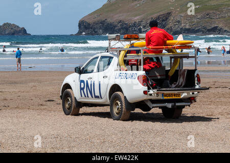Bagnini dal RNLI guardare i surfisti e bodyboarders su Polzeath Beach, Cornwall, Regno Unito. Foto Stock