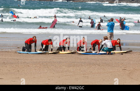 Scuola di Surf lezioni di surf sulla spiaggia di Polzeath Cornwall, Regno Unito, gli studenti sono inginocchiati sulle loro tavole da surf Foto Stock