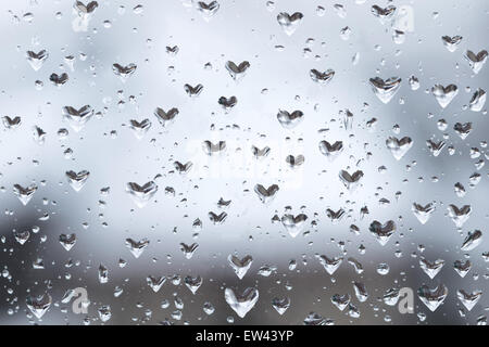 A forma di cuore le goccioline di acqua sulla finestra Foto Stock