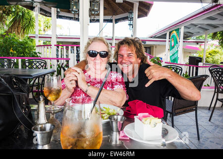 A 78 anni donna caucasica è imbarazzato da un estraneo abbraccio sulla terrazza di un caffè sulla spiaggia. St. Croix, U.S. Isole Vergini. USVI, U.S.V.I. Foto Stock