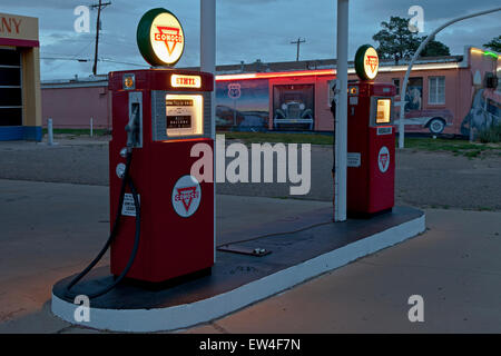 Vintage Conoco pompe di benzina accesa al tramonto lungo la Route 66 in Tucamcari, Nuovo Messico. Foto Stock