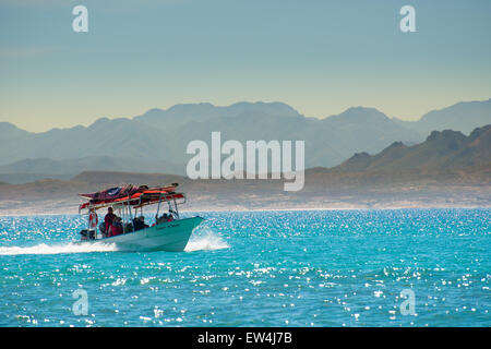 Messico, Baja, Lapaz, Espiritu Santo. I turisti a cavallo in barca. Foto Stock