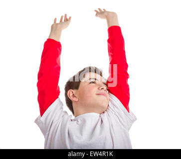 Ragazzo caucasico è lo stiramento solleva le braccia e le mani e guardando in alto Foto Stock