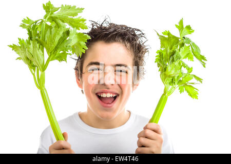 Bel ragazzo ispanica con morbido in pelle bianca con maniche lunghe t-shirt è sorridente tenendo sedano verde bastoni con entrambe le mani Foto Stock