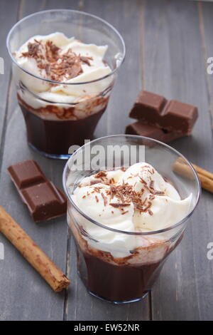 Fresco frullato al cioccolato con crema di latte sul tavolo di legno Foto Stock