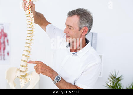 Medico che mostra la colonna vertebrale anatomica Foto Stock