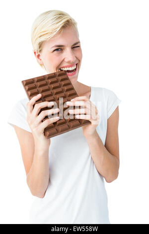 Donna attraente mordere barretta di cioccolato Foto Stock