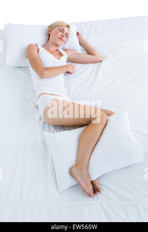 Donna bionda dormire nel suo letto Foto Stock