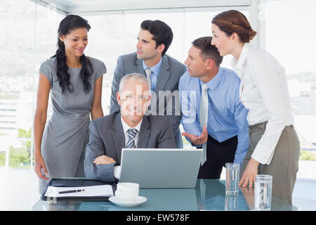 Il team Aziende a lavorare felicemente insieme sul computer portatile Foto Stock