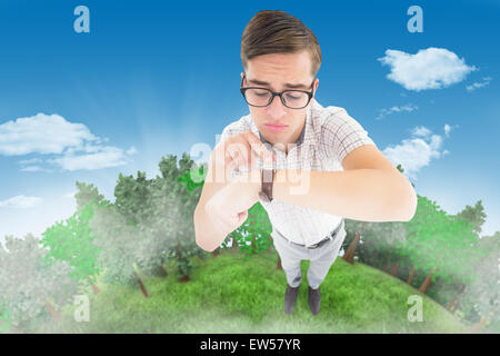 Immagine composita di geeky hipster rivolta verso il suo orologio Foto Stock