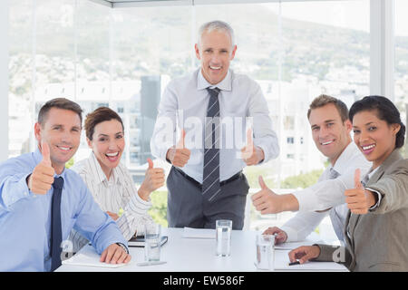 Il team di Business sorridente in Telecamera che mostra pollice in alto Foto Stock