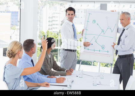 Imprenditore spiegando il grafico sulla lavagna Foto Stock
