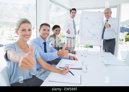 Il team di Business sorridente in Telecamera che mostra pollice in alto Foto Stock