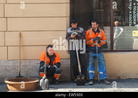 San Pietroburgo, Russia - 30 Maggio 2015: uomini al lavoro, strada urbana in costruzione, asfaltatura, gruppo dei lavoratori con pale Foto Stock