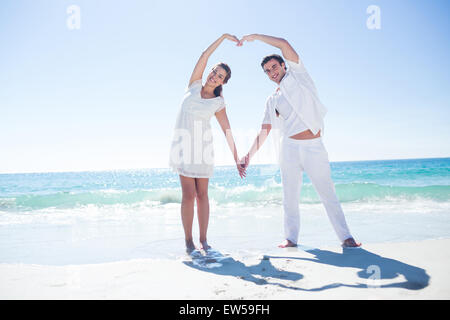 Felice coppia formando forma di cuore con le loro mani Foto Stock