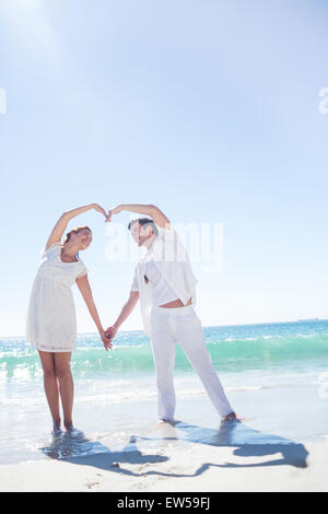 Felice coppia formando forma di cuore con le loro mani Foto Stock