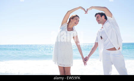 Felice coppia formando forma di cuore con le loro mani Foto Stock