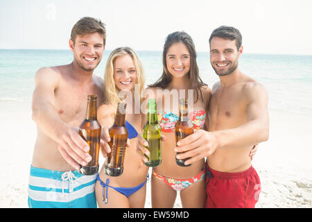 Gruppo di amici in costume da bagno il tifo con birre Foto Stock