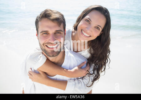 Uomo bello fare piggy-back per la sua ragazza Foto Stock