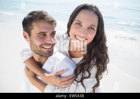 Uomo bello fare piggy-back per la sua ragazza Foto Stock