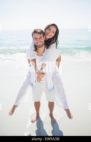 Uomo bello fare piggy-back per la sua ragazza Foto Stock