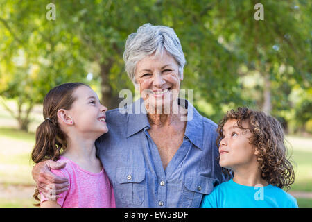 Famiglia estesa sorridente e baciare in un parco Foto Stock