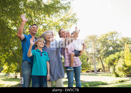 La famiglia felice sventolare le mani nel parco Foto Stock