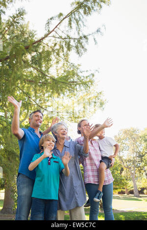 La famiglia felice sventolare le mani nel parco Foto Stock