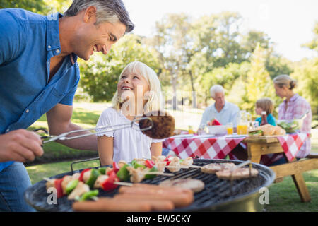 Padre felice di fare barbecue con sua figlia Foto Stock