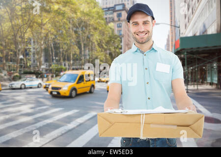 Immagine composita del corriere bello uomo con pacco Foto Stock