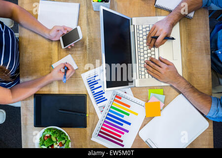 Partner di lavoro alla scrivania con computer portatile e lo smartphone Foto Stock