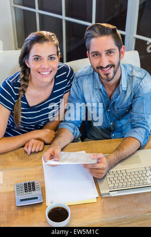 Partner di lavoro alla scrivania e sorridente in telecamera Foto Stock