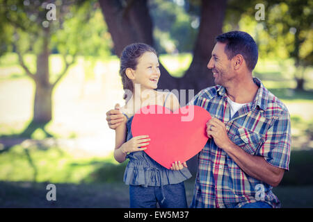 Padre e figlia tenendo un cuore nel parco Foto Stock