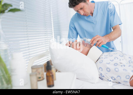 I medici tenendo i pazienti le maschere di ossigeno Foto Stock