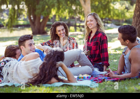 Happy amici nel parco con picnic e a suonare la chitarra Foto Stock