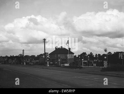 La Oxford Road a Denham, Tatling fine stazione di riempimento benzina affollate di antiestetici segni. Circa 1931 Foto Stock