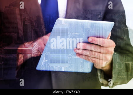 Immagine composita di imprenditore a scorrere sul suo tavoletta digitale Foto Stock