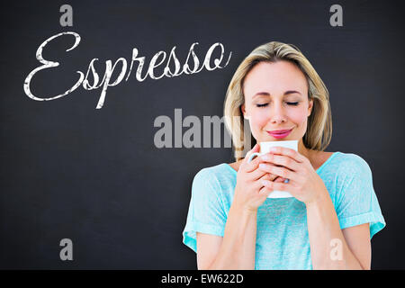 Immagine composita di allegro bionda tazza di contenimento di bevande calde Foto Stock