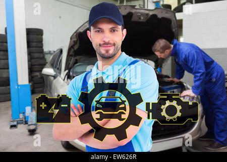 Immagine composita del maschio sorridente tuttofare in tute in piedi con le braccia incrociate Foto Stock