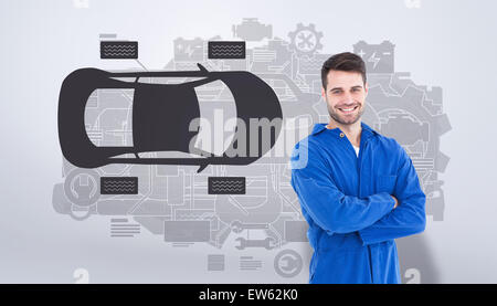 Immagine composita di sorridere giovane maschio machanic in piedi con le braccia incrociate Foto Stock