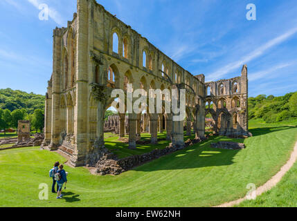 I turisti davanti alle rovine di Rievaulx Abbey, vicino a Helmsley, North Yorkshire, Inghilterra, Regno Unito Foto Stock