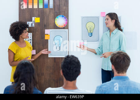 Casual giovane imprenditrice dando la presentazione ai colleghi Foto Stock