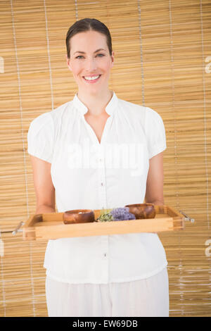 Sorridente terapista di bellezza tenendo il vassoio di trattamenti di bellezza Foto Stock