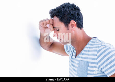 Triste uomo appoggiato la sua testa contro una parete Foto Stock