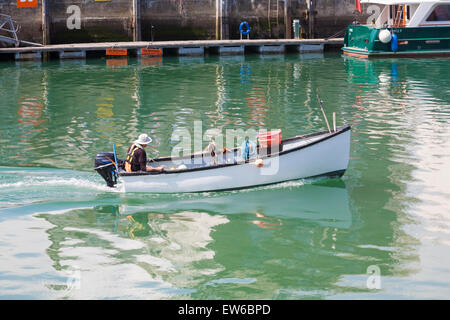 Uomo di lasciare il porto in barca da pesca a Weymouth Dorset, in giugno Foto Stock