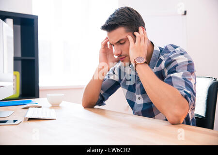 Malinconici imprenditore seduti a tavola in office Foto Stock