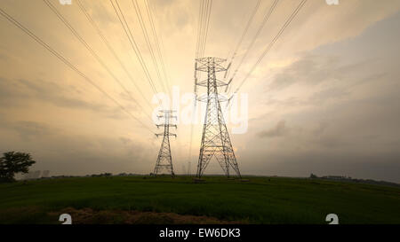 Ora d'oro al tramonto e silhouette di due della potenza di trasmissione torri di elettricità Foto Stock