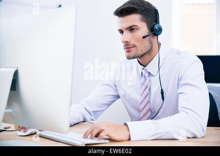 Operatore telefonico di assistenza clienti giovane e bello con cuffie in  funzione nel call center Foto stock - Alamy