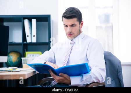 Imprenditore seduti a tavola e la lettura di documenti office Foto Stock