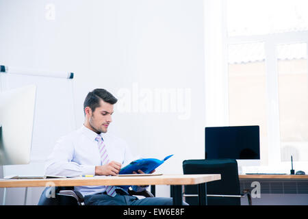 Imprenditore seduti a tavola e la lettura di documenti office Foto Stock